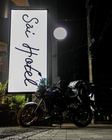 夜のソロツーリングでSai Hotelに到着したホンダCB250R。街灯とホテルの看板に照らされたバイクの夜景スナップ。
