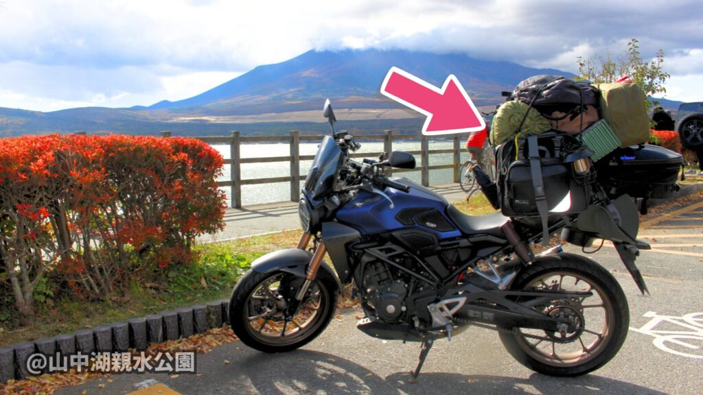 CB250Rにキャンプ装備をフル積載したパッキング実例。シートバッグの上にさらに荷物を追加した状態のバイクの写真(場所:山中湖親水公園の駐車場)。
