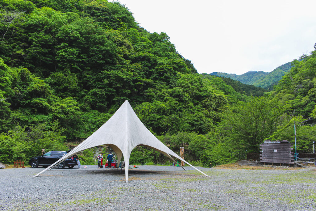 蜂花苑キャンプ場フリーサイトの星型スターシェード、山々に囲まれた開放的な芝生エリア