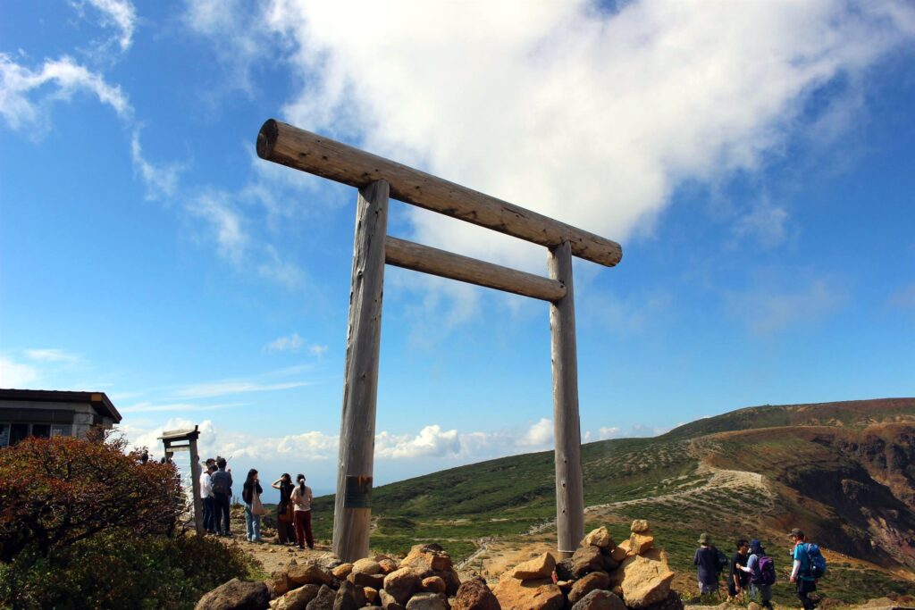 蔵王のシンボル「御釜」のエメラルドグリーンの火口湖と鳥居。