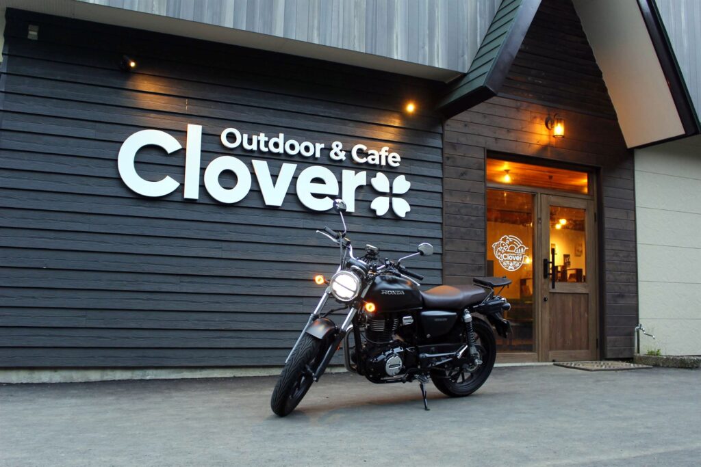 夜のカフェ「Outdoor & Cafe Clover」の外観とレンタルバイク。